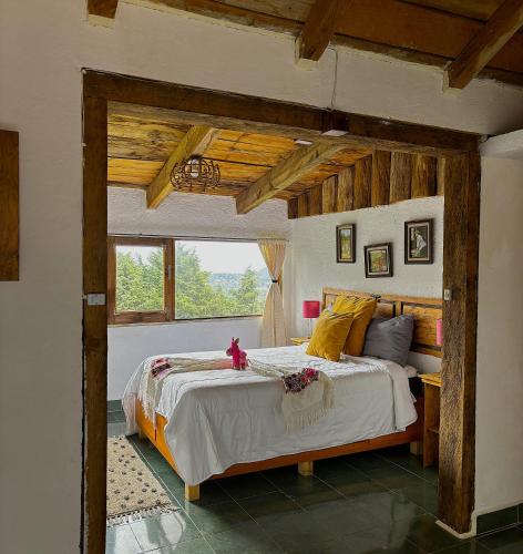a bedroom with a large bed in a room with wooden ceilings at Rancho EL PARAÍSO AJUSCO in Mexico City