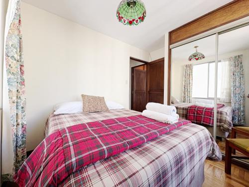 a bedroom with a bed and a mirror at Apartamento con hermosa vista y soleado en Sopocachi in La Paz