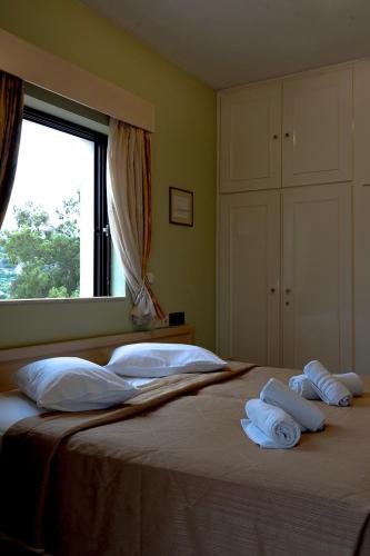 a bedroom with a bed with white pillows and a window at Hotel Marilen in Alinda