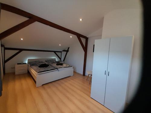 a bedroom with a bed and a white cabinet at Haus Helmuth in Süderdeich