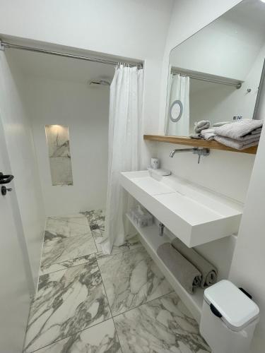 une salle de bain blanche avec un lavabo et un miroir dans l'établissement LutherStudios, à Schleswig