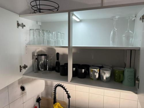 a kitchen shelf with glass items on it at Usedom Suite Zeitlos - 100 Meter zum Strand in Ostseebad Koserow