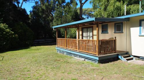 a screened in porch on a house at Strahan Retreat Holiday Park in Strahan
