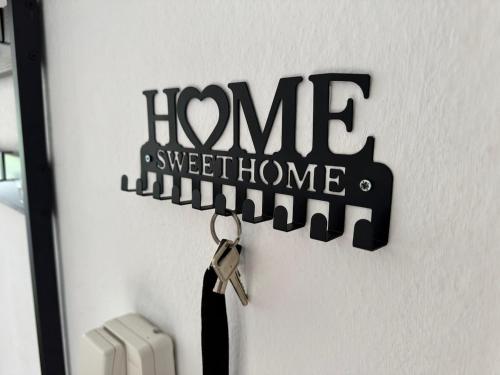 a sign that reads home sweet home hanging on a door at Usedom Suite Zeitlos - 100 Meter zum Strand in Ostseebad Koserow