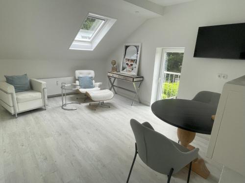 - un salon avec une table, des chaises et un miroir dans l'établissement LutherStudios, à Schleswig