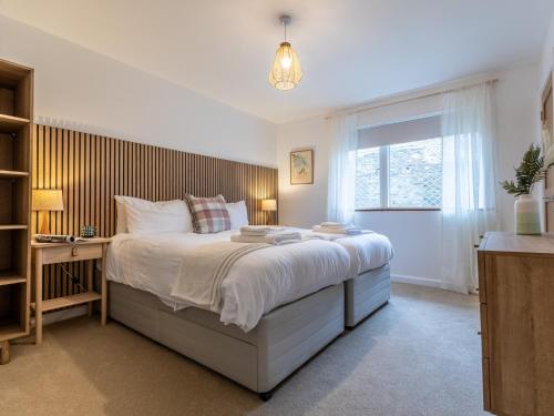 a bedroom with a bed and a desk and a window at 3 Bed in Braunton 86042 in Braunton