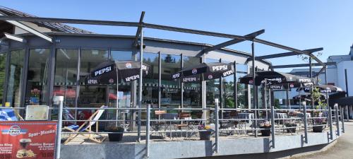 a restaurant with umbrellas in front of a building at TOP KaVi apartments #7, Pool, Sauna und Fitness FREE, 2-Zimmer in Sankt Englmar