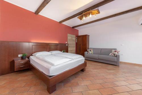 una camera da letto con un letto grande e un divano di Ražman Wine Rooms a Gračišče