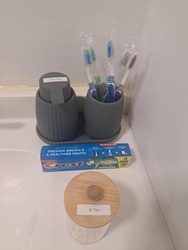 a couple of toothbrushes in a container on a counter at Fun Home in Pocono with Gameroom-Firpit-BBQ Grill-TV and AC in all rooms in Tobyhanna