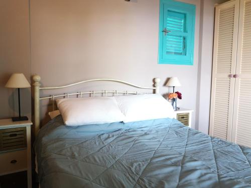 a bedroom with a bed and two night stands with lamps at The Iconpainter Zaga Villa in Kómboi