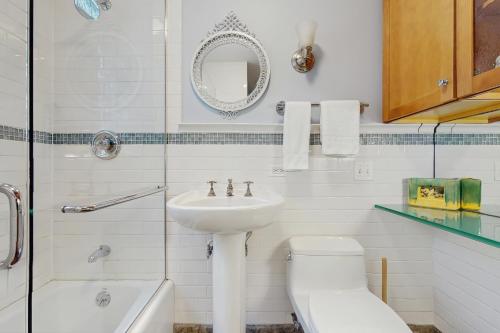 Un baño blanco con lavabo e inodoro. en Happy Thoughts Cottage, en New Buffalo
