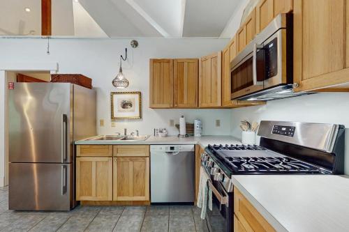 a kitchen with wooden cabinets and stainless steel appliances at The Lemonade Stand in West Tisbury