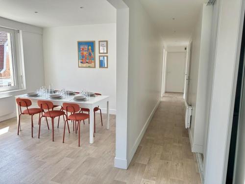 a white dining room with a white table and chairs at Apartment in city center - Garage - Beach 200 m in Berck-sur-Mer