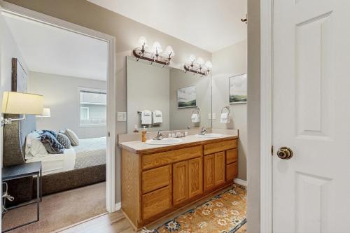 a bathroom with a sink and a bed and a mirror at Fox Hollow Home in Whitefish