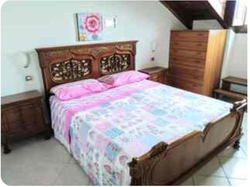 a bedroom with a large bed with pink pillows at La Mansarda 800metri da Ravello in Scala