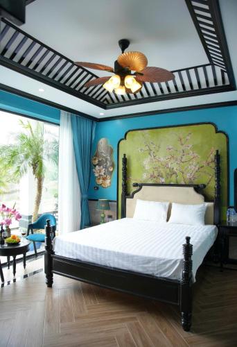 a bedroom with a bed and a ceiling fan at Tam Coc Ecolodge in Vũ Lâm