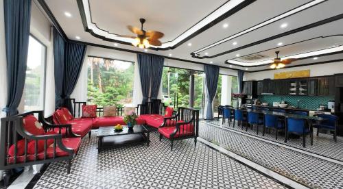a living room with red furniture and a dining room at Tam Coc Ecolodge in Vũ Lâm
