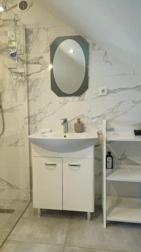 a bathroom with a white sink and a mirror at Agroturystyka Pokój na Skarpie in Kowale Oleckie