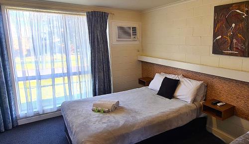 a hotel room with a bed with a window at Dartmoor Hotel Motel in Dartmoor