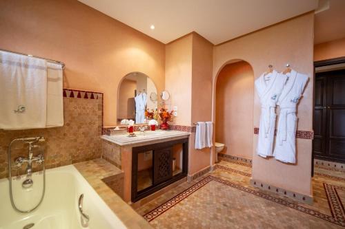 a bathroom with a tub and a sink and a shower at Al Fassia Aguedal in Marrakech
