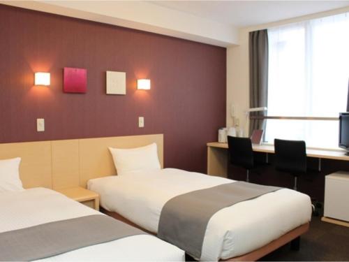 a hotel room with two beds and a desk at Quad Inn Yokote - Vacation STAY 59868v in Yokote