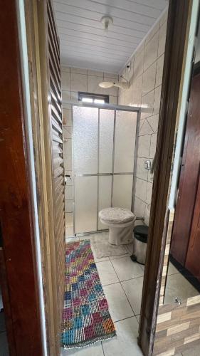 a bathroom with a toilet and a rug on the floor at Casa design Piri no centro de Pirenópolis in Pirenópolis