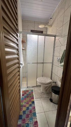a bathroom with a shower and a toilet and a rug at Casa design Piri no centro de Pirenópolis in Pirenópolis