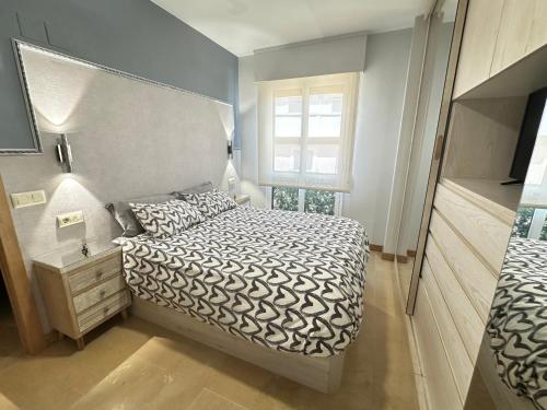 Un dormitorio pequeño con una cama y una ventana. en Acogedor apartamento con acabados primera calidad, en Zaragoza