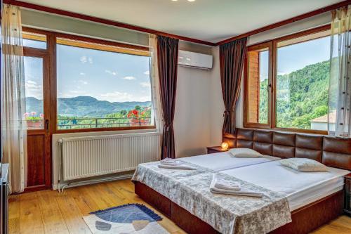 a bedroom with a bed and a large window at При Баръма in Vishnevo