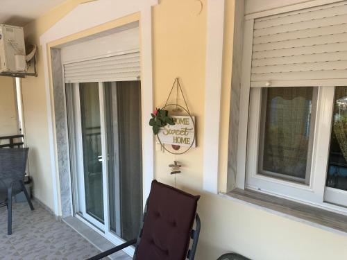 a porch with two windows and a chair and a sign at TONI HOuSE in Alexandroupoli