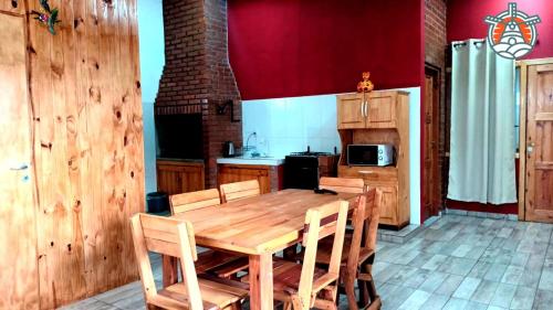 eine Küche mit einem Holztisch mit Stühlen und einem Herd in der Unterkunft Departamento Tio Iguazú in Puerto Iguazú