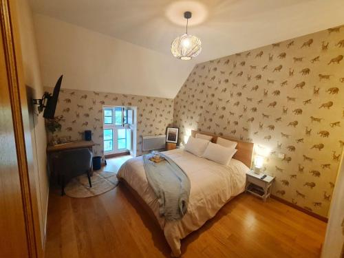 a bedroom with a bed and a wall with birds on it at La Hulottière in Saint-Rémy-du-Plein
