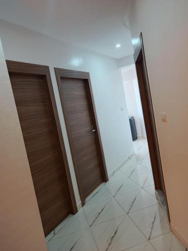 two wooden doors in a hallway with a tile floor at El jadida in El Jadida