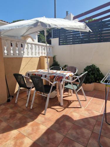 a table and chairs under an umbrella on a patio at Apartamento Riells in L'Escala