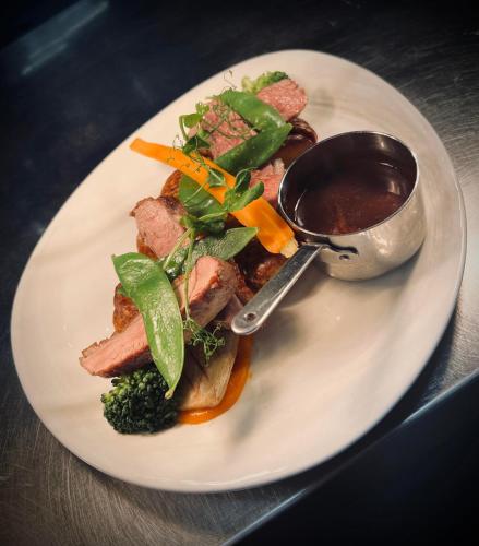 a plate of food with meat and vegetables and sauce at The Knowes Hotel & Restaurant in Macduff