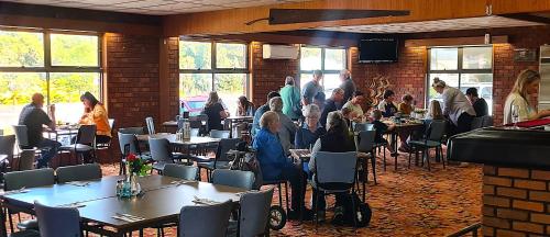a group of people sitting at tables in a restaurant at Dartmoor Hotel Motel in Dartmoor