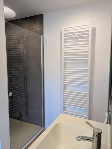 a bathroom with a sink and a shower at Emden - Ferienwohnung mit Kanal-Blick in Emden