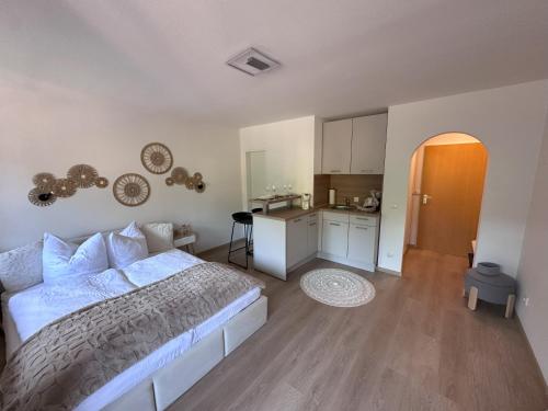 阿尔高内的伊门施塔特Alpenglück的一间带白色床的卧室和一间厨房