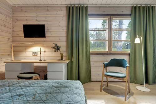 a bedroom with a bed and a desk with a monitor at Lapland Fellas - Äkäslompolo in Äkäslompolo