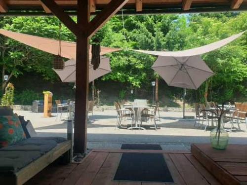 a patio with umbrellas and a table and chairs at Locanda EL TORO in Arnoldstein