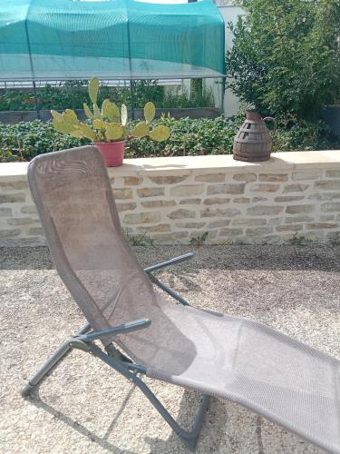 a metal chair sitting in front of a wall at Logement pleine nature in Saint-Bris-le-Vineux