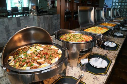 a buffet line with many different types of pizzas at Hotel Nacional Inn Poços de Caldas - Lazer completo e Gastronomia no Centro in Poços de Caldas