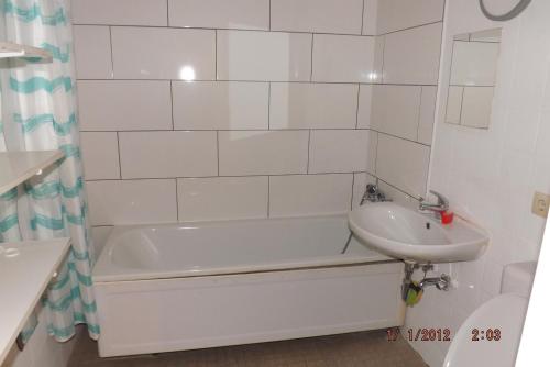 a white bathroom with a tub and a sink at GME Easyflex Home-1 in Berlin