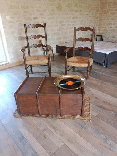 a room with chairs and a table with a bowl on a chest at Logement pleine nature in Saint-Bris-le-Vineux