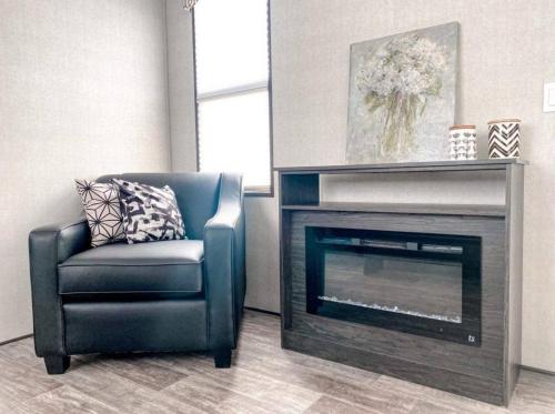 a living room with a chair and a fireplace at The Balmoral at Duck Lake in Carden