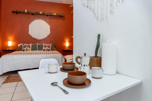 a room with a bed and a table with cups on it at Parking, 6min to Beach & Downtown, High-Speed WiFi, Laundry Service, KingBed, PetsOK in Sayulita