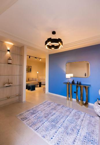 a living room with a blue wall and a large rug at Luxury Modern Studio Ensuite By Beithady BH-26-004 in New cairo