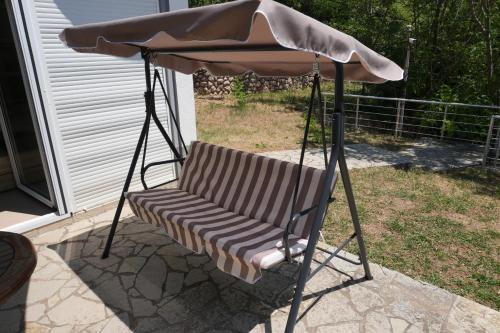 a swing chair under an umbrella on a patio at Vila Brca in Brca