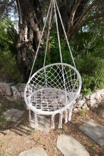 a white swinging chair in front of a tree at Vila Brca in Brca