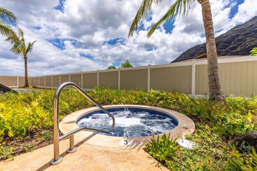 a hot tub in a yard with palm trees at Makaha Villa by AvantStay Mountain Ocean Views in Waianae